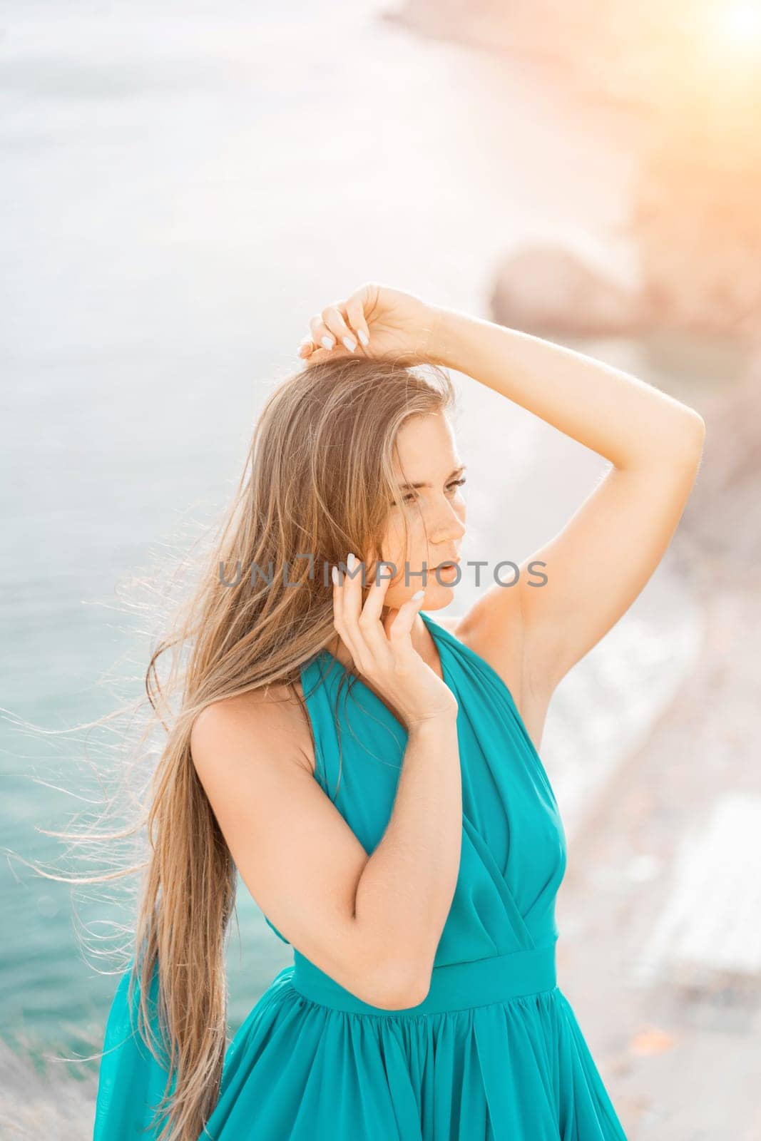 Woman sea green dress. Portrait of a happy woman with long hair in a long mint dress posing on a beach with calm sea bokeh lights on sunny day. Girl on the nature on blue sky background