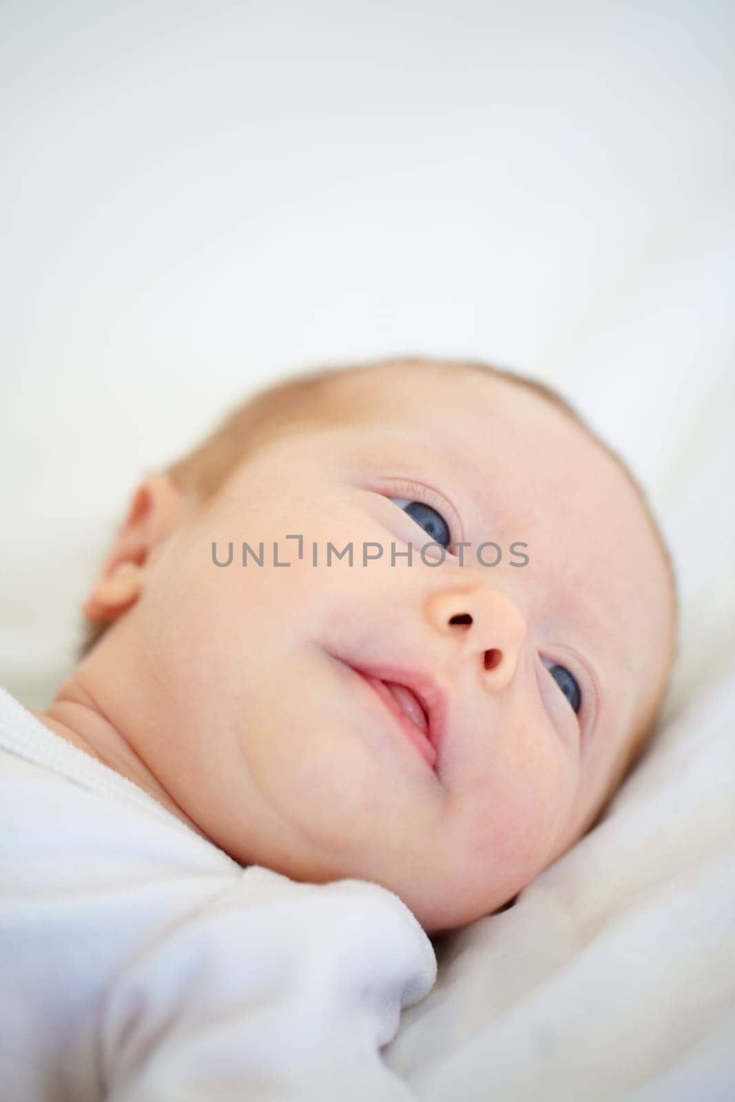 Closeup, baby and face for wake up on bed from good dream, sleep or nap in nursery. Infant, looking and relaxing on pillow for child growth, cognitive and development in hope for milestone of future.