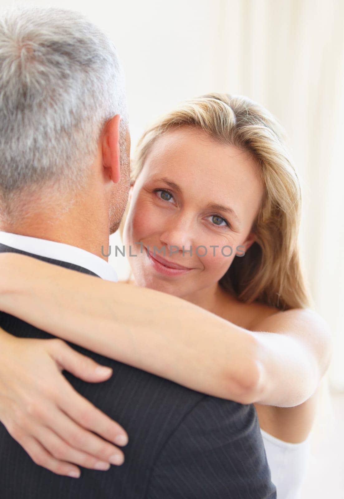 Portrait, love and a woman hugging her husband on their wedding day for romance or commitment. Face, smile and a bride embracing her groom for trust, safety or security during a marriage ceremony.