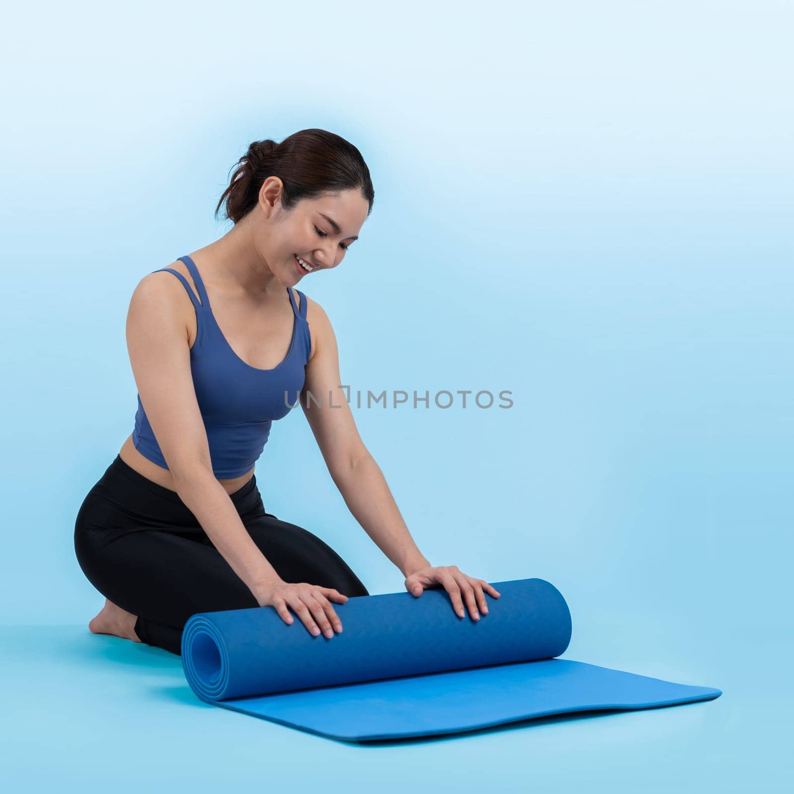 Young attractive asian woman portrait in sportswear with exercising mat. Healthy exercise and workout routine lifestyle concept. Studio shot isolated background. Vigorous