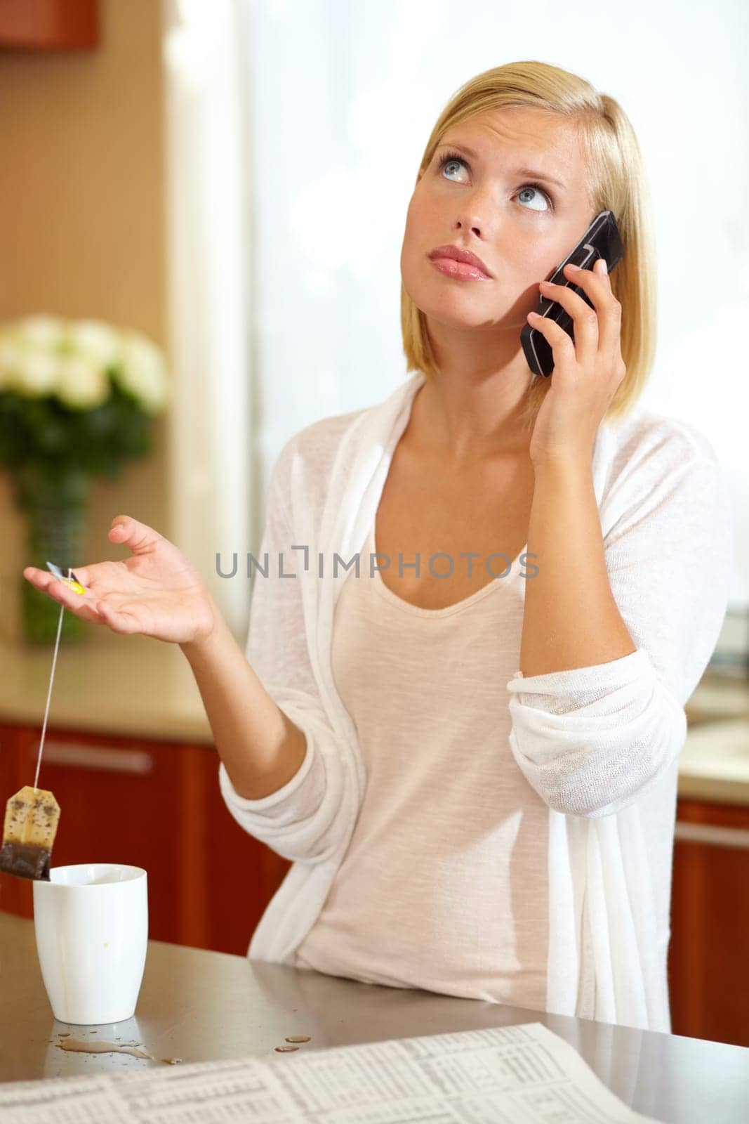 Woman, phone call and conversation in kitchen, news and communication on technology at home. Female person, smartphone and discussion or tea, connection and newspaper or newsletter, chat and talk by YuriArcurs