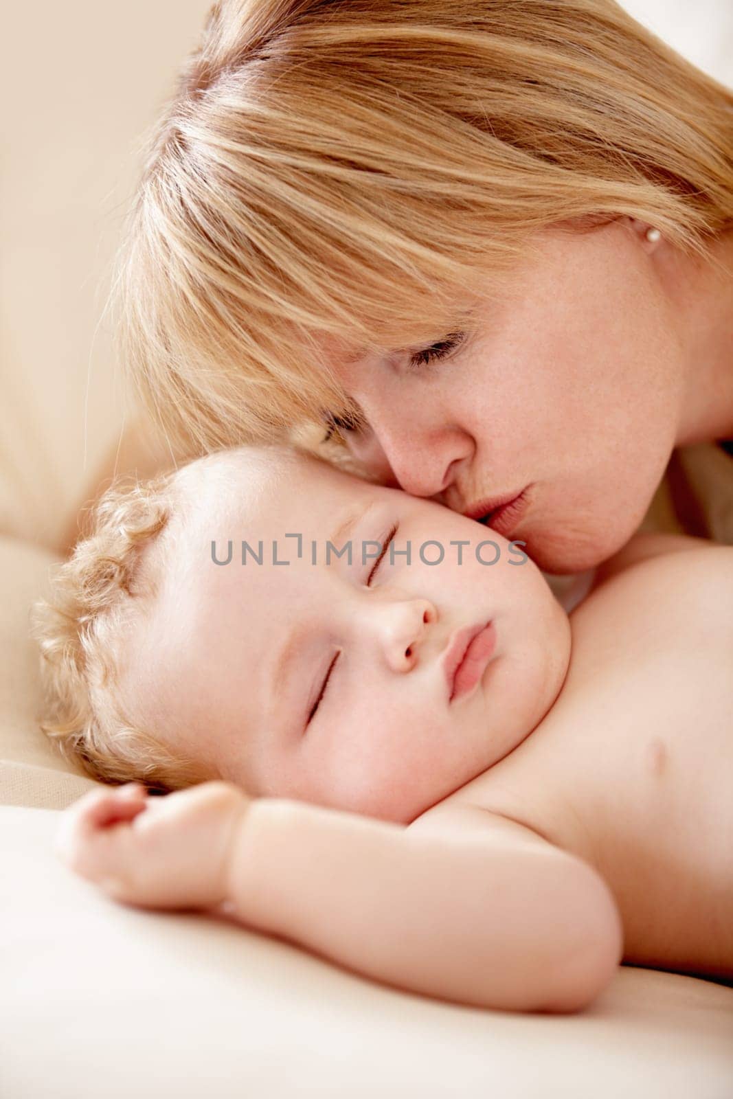 Family, love and a mother kissing her baby closeup on a bed in their home for bonding together. Face, sleeping and an infant child in the bedroom of an apartment with his woman parent for affection by YuriArcurs