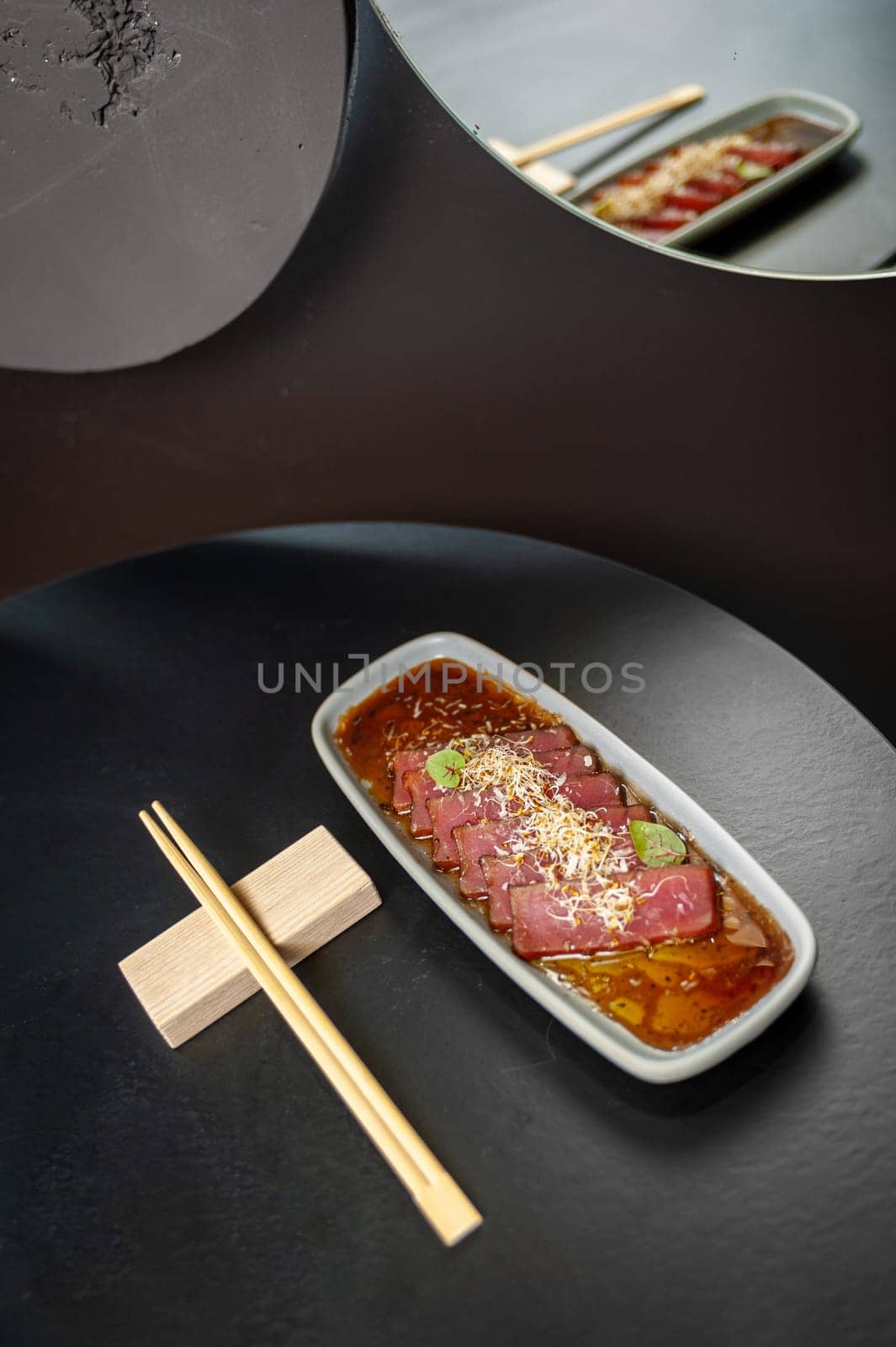 Marinated tuna in soy dressing with fresh soy sprouts on a black table in a restaurant. High quality photo