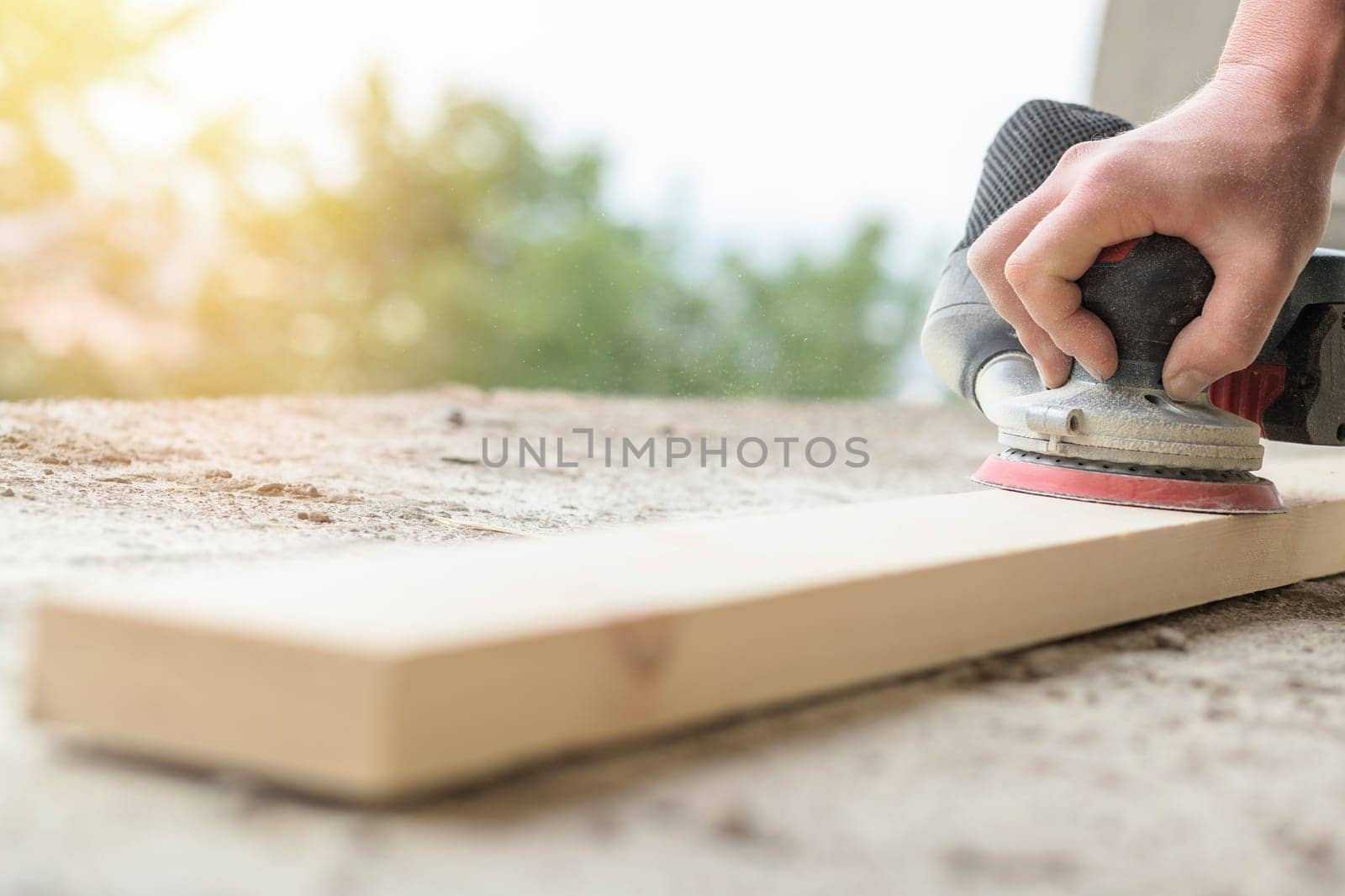 Close-up on a wooden board being sanded with grinder machine, copy space.