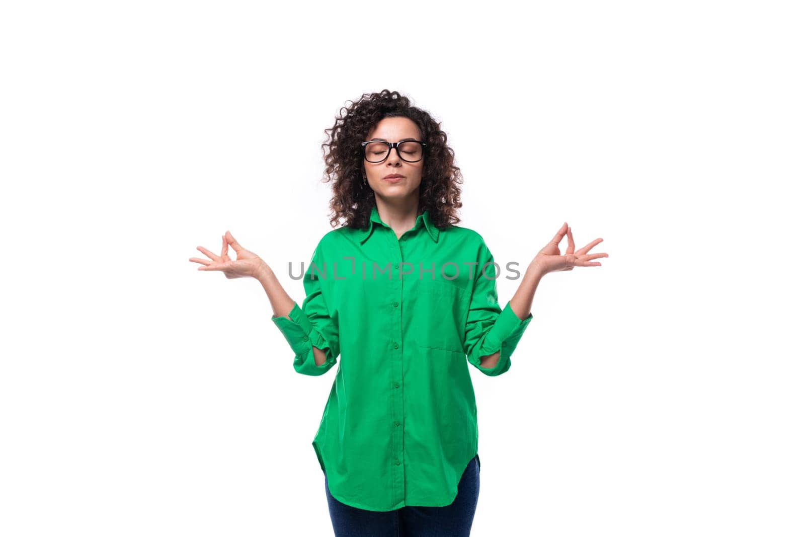 brunette young caucasian lady with curly hair dressed in a green shirt is waiting for the fulfillment of a wish.