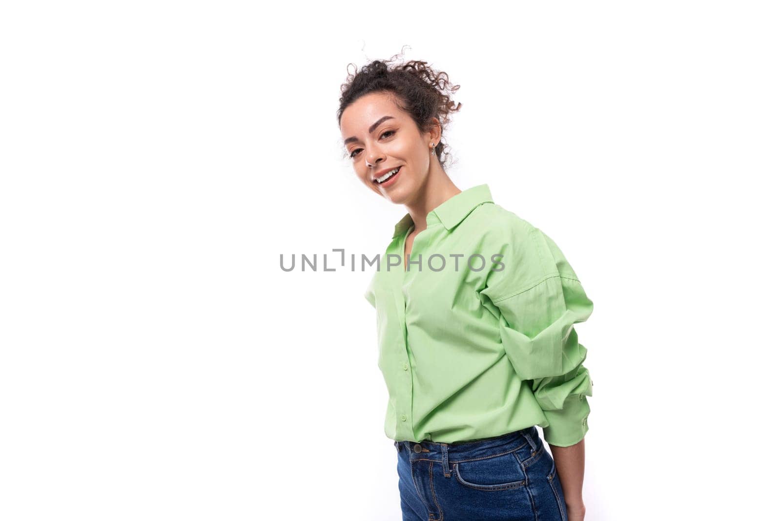 young slender european brunette curly woman with a ponytail hairstyle is dressed in a green shirt by TRMK