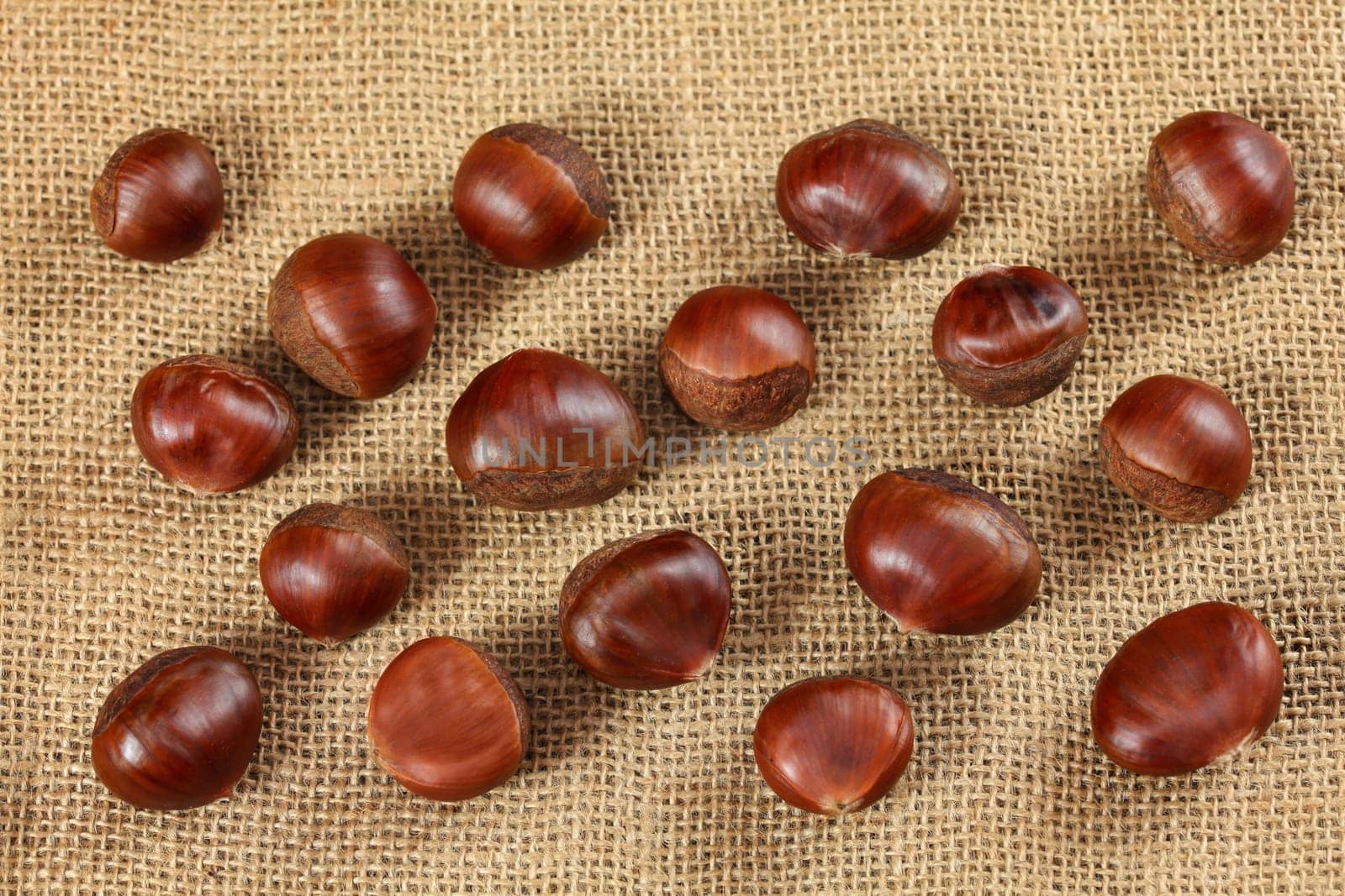 Overhead shot - glossy chestnuts on jute cloth by Ivanko