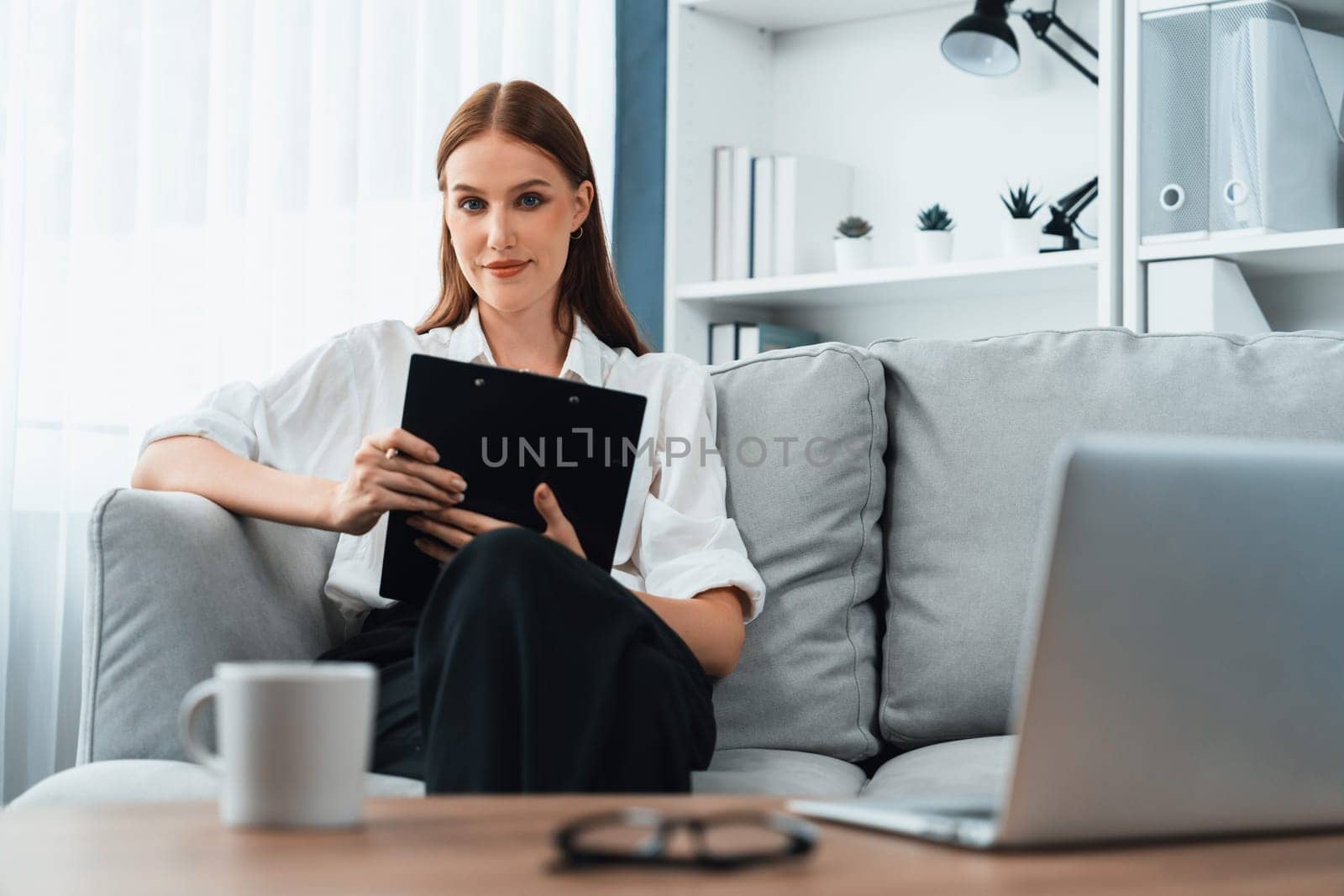 Psychologist woman in clinic office professional portrait with friendly smile feeling inviting for patient to visit the psychologist. The experienced and confident psychologist is utmost specialist