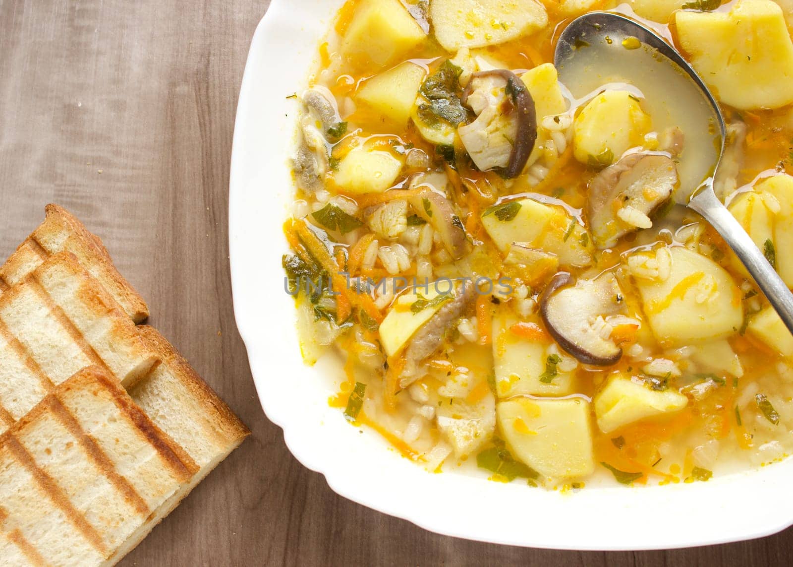 Mushroom soup in a white bowl on a beige background. High quality photo