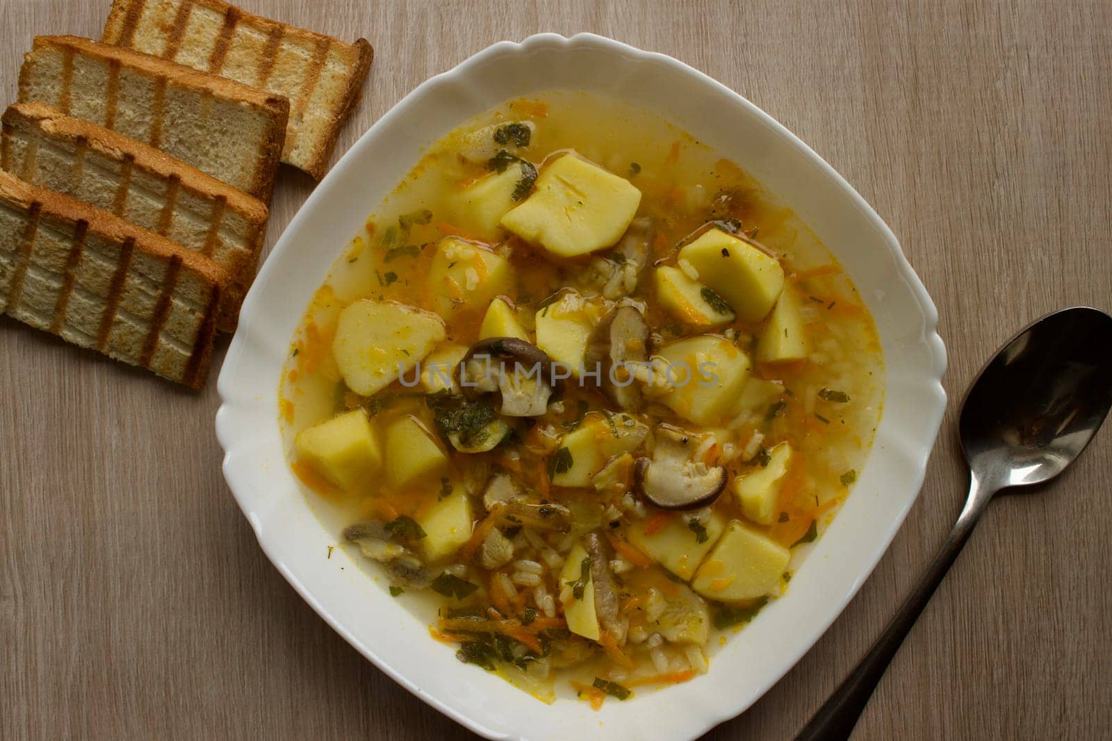 Mushroom soup in a white bowl on a beige background. High quality photo