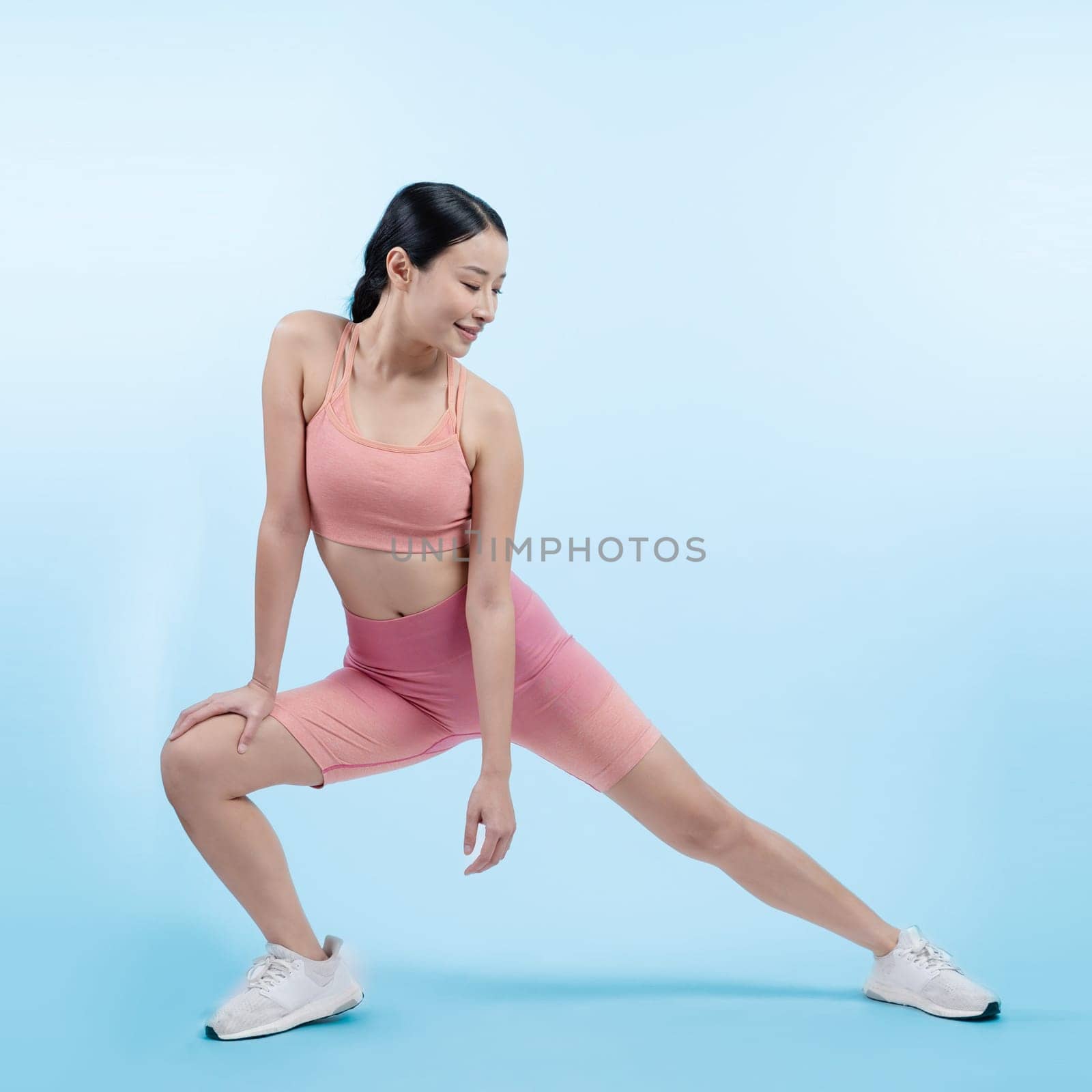 Young attractive asian woman in sportswear stretching. Vigorous by biancoblue