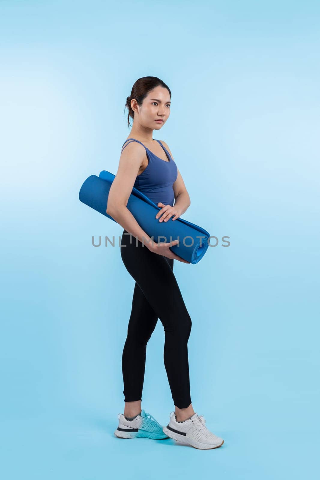 Young attractive asian woman portrait in sportswear with exercising mat. Healthy exercise and workout routine lifestyle concept. Studio shot isolated background. Vigorous