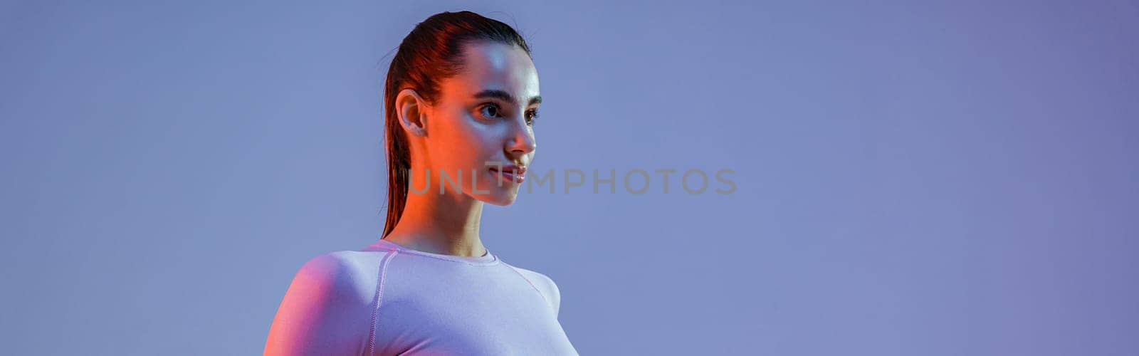 Fitness woman doing exercises with dumbbells on studio background and looking at side by Yaroslav_astakhov