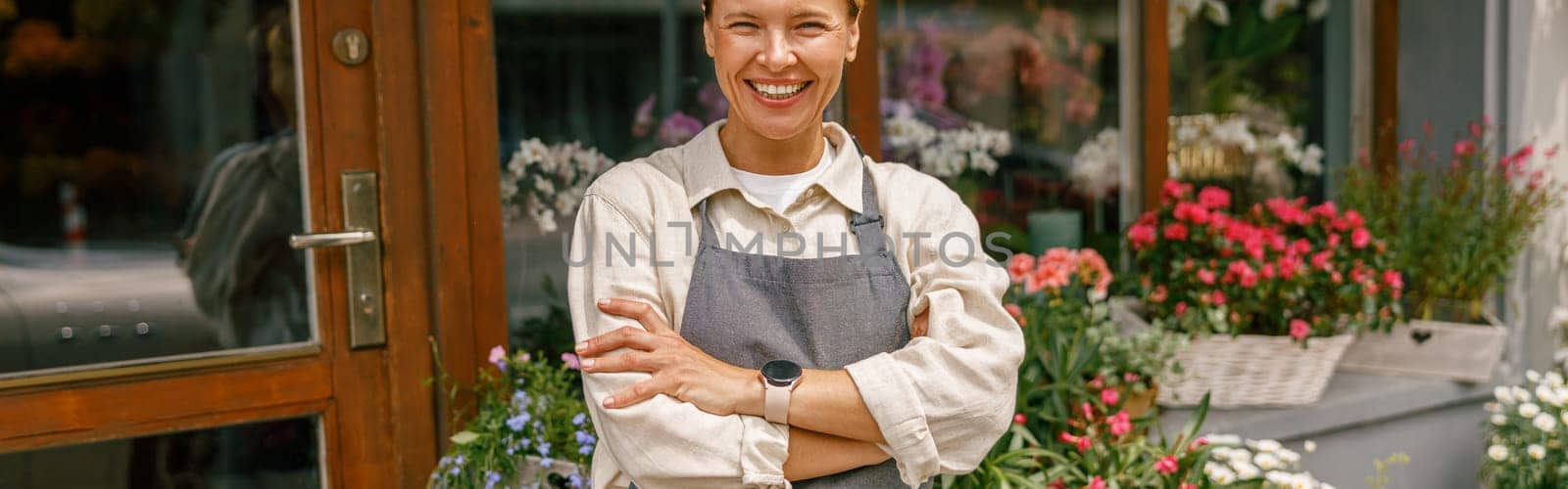 Woman florist small business owner standing with crossed arms near floral store. High quality photo