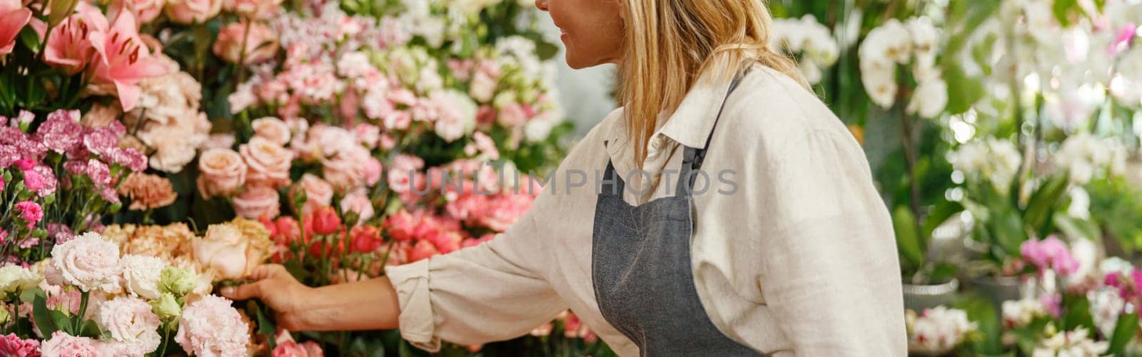 Smiling woman florist small business owner standing in own floral store and waiting for client by Yaroslav_astakhov