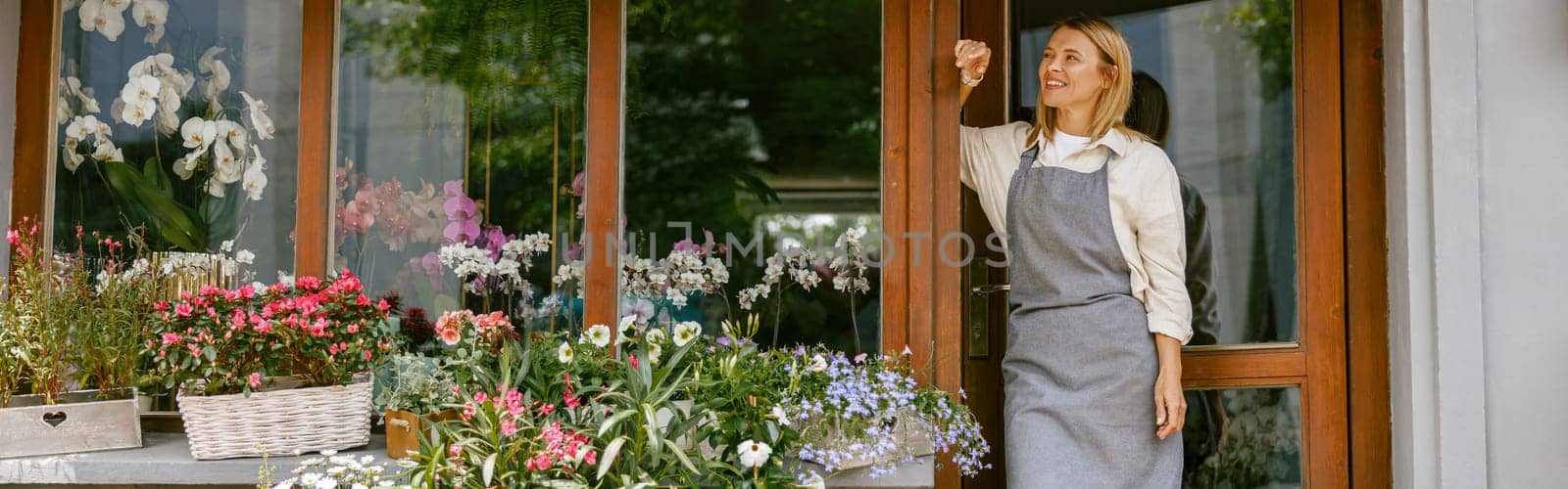 Professional woman gardener small business owner standing in own floral store and waiting for client by Yaroslav_astakhov