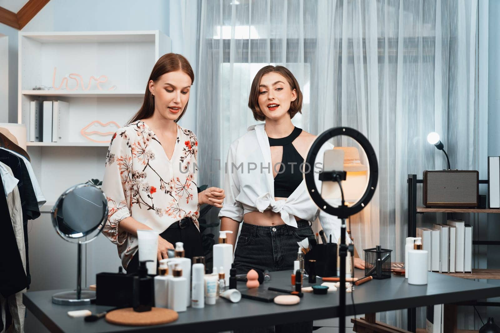 Woman influencer shoot live streaming vlog video review makeup utmost social media or blog. Happy young girl with cosmetics studio lighting for marketing recording session broadcasting online.