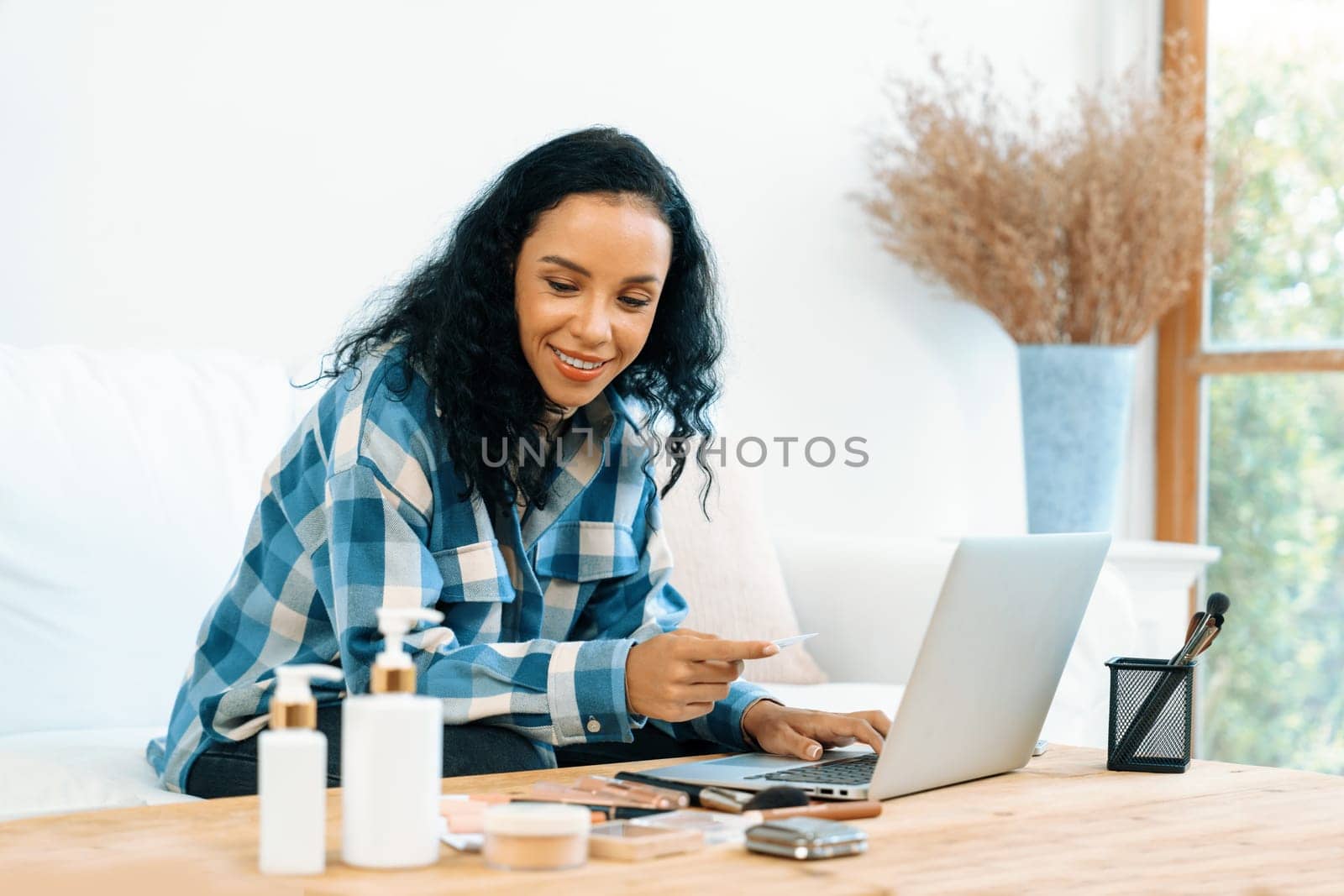 Young happy woman buy product by online shopping at home while ordering items from the internet with credit card online payment system protected by crucial cyber security from online store platform