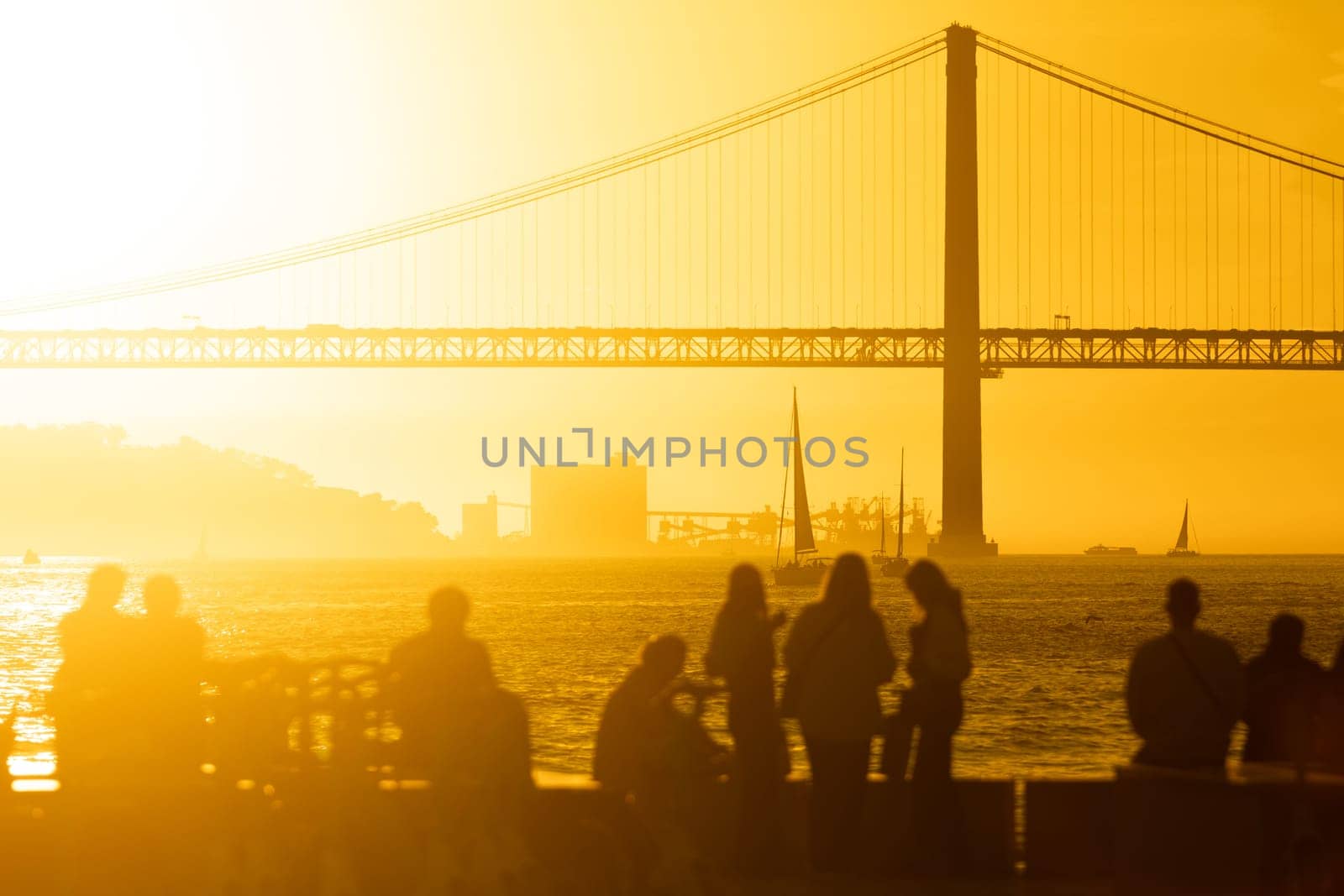A Serene Sunset Overlooking a Majestic Bridge with a Group of People by Studia72
