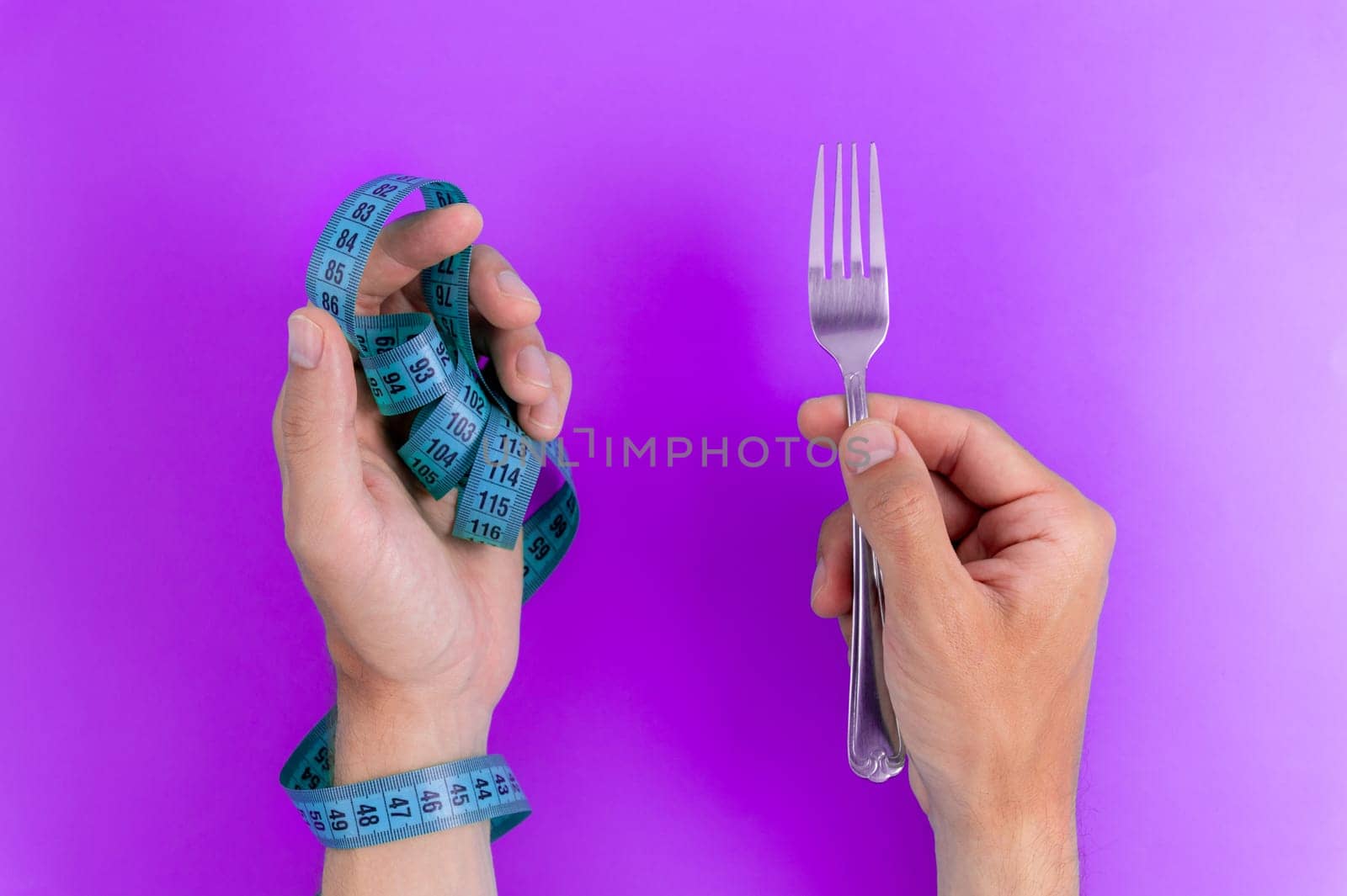 Diet concept, measuring tape, weight loss. Diet concept. Hand holding fork with tape measure on color background by yanik88