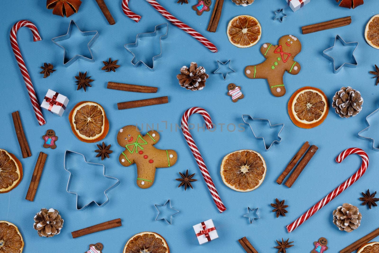 Christmas food frame. Gingerbread cookies, spices and decorations on blue background with copy space
