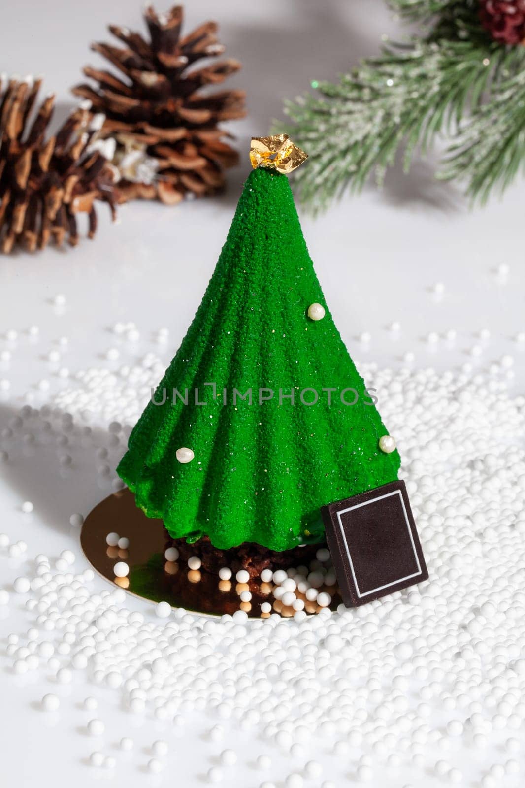 Green Christmas tree shaped cake with fir branch and cones by nazarovsergey