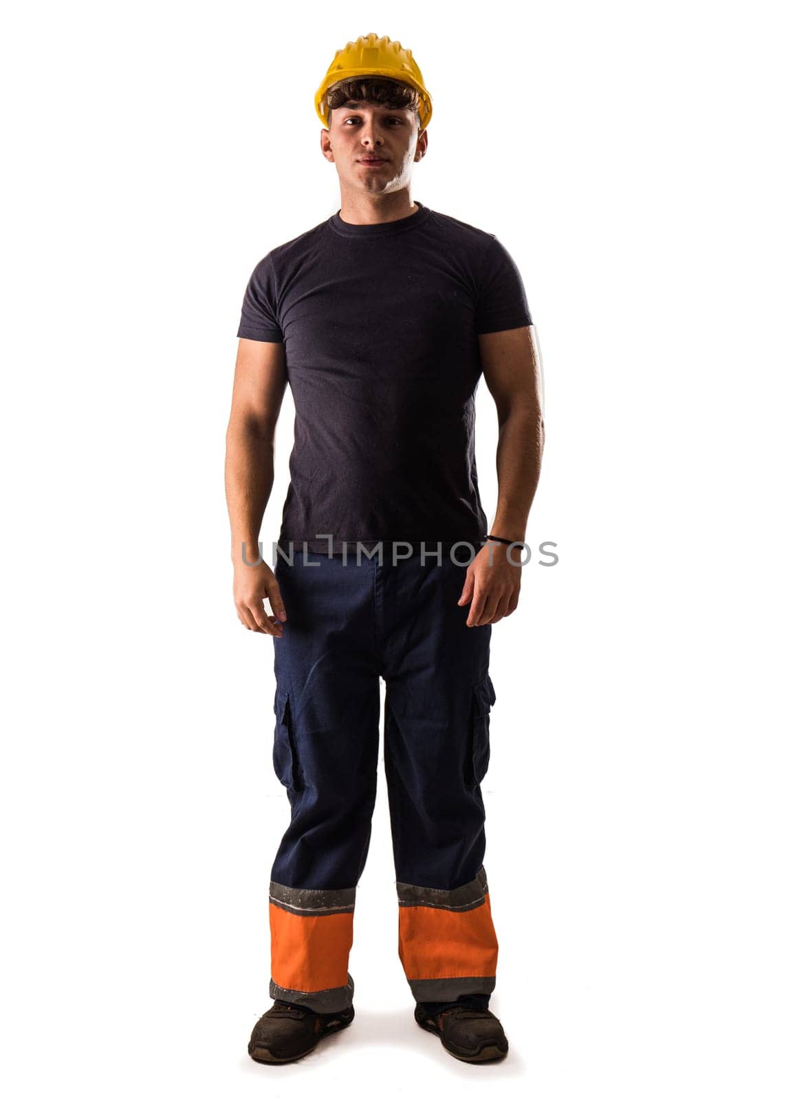 A young man wearing a hard hat and overalls, isolated on white in studio shot. Full length