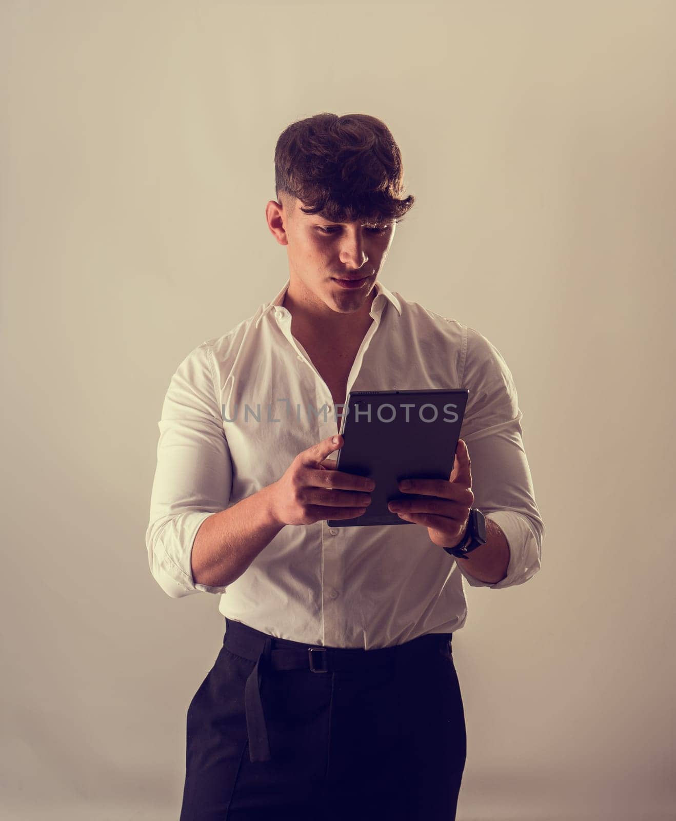 A Curious Man in a Crisp White Shirt Engrossed in a Technological Tablet by artofphoto