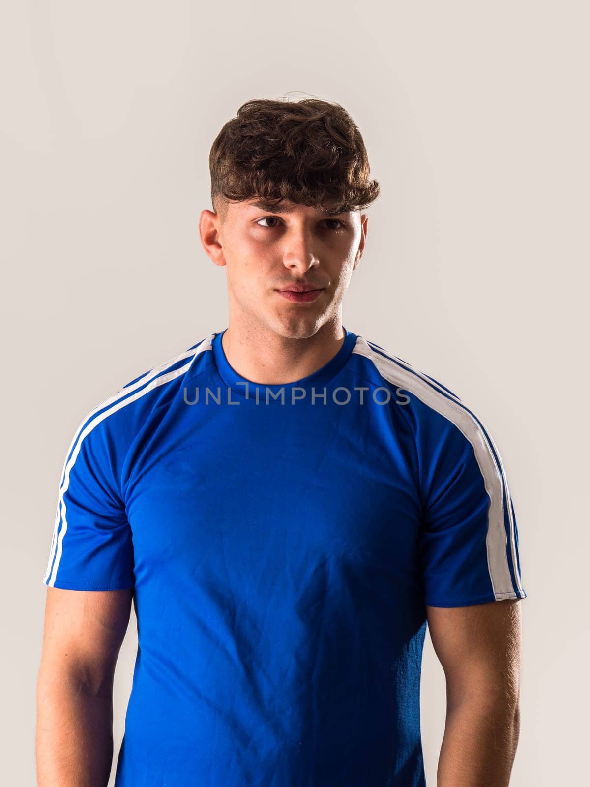 Posing with Confidence: A Stylish Young Man Captured in a Blue Soccer Shirt by artofphoto