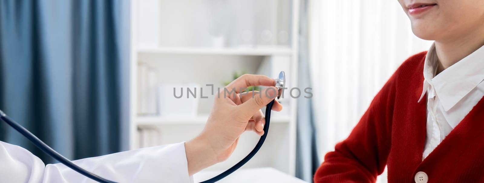 Patient attend doctor's appointment at clinic or hospital office. Doctor examining and diagnosis symptoms while checking the patient's pulse with stethoscope. Panorama Rigid