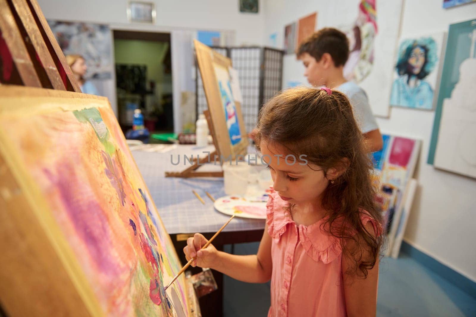 Talented kids, inspired artists painters enjoying creative hobby indoors, painting with watercolors in art workshop by artgf