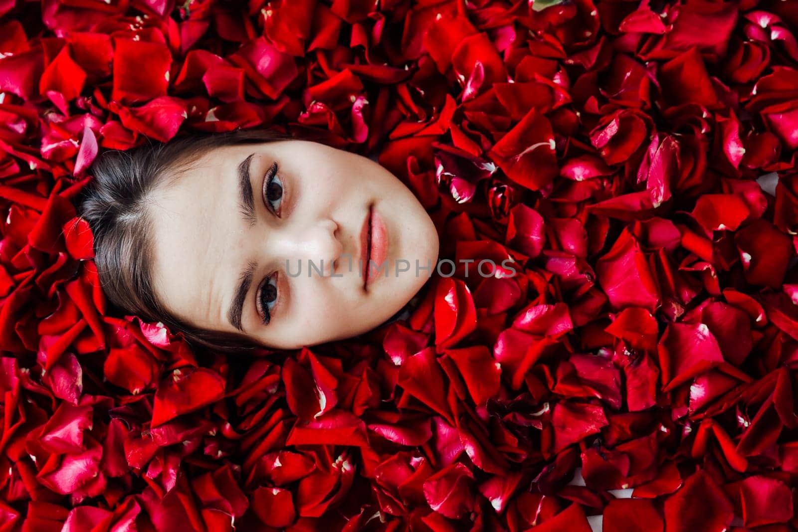 woman's face in the petals of red roses