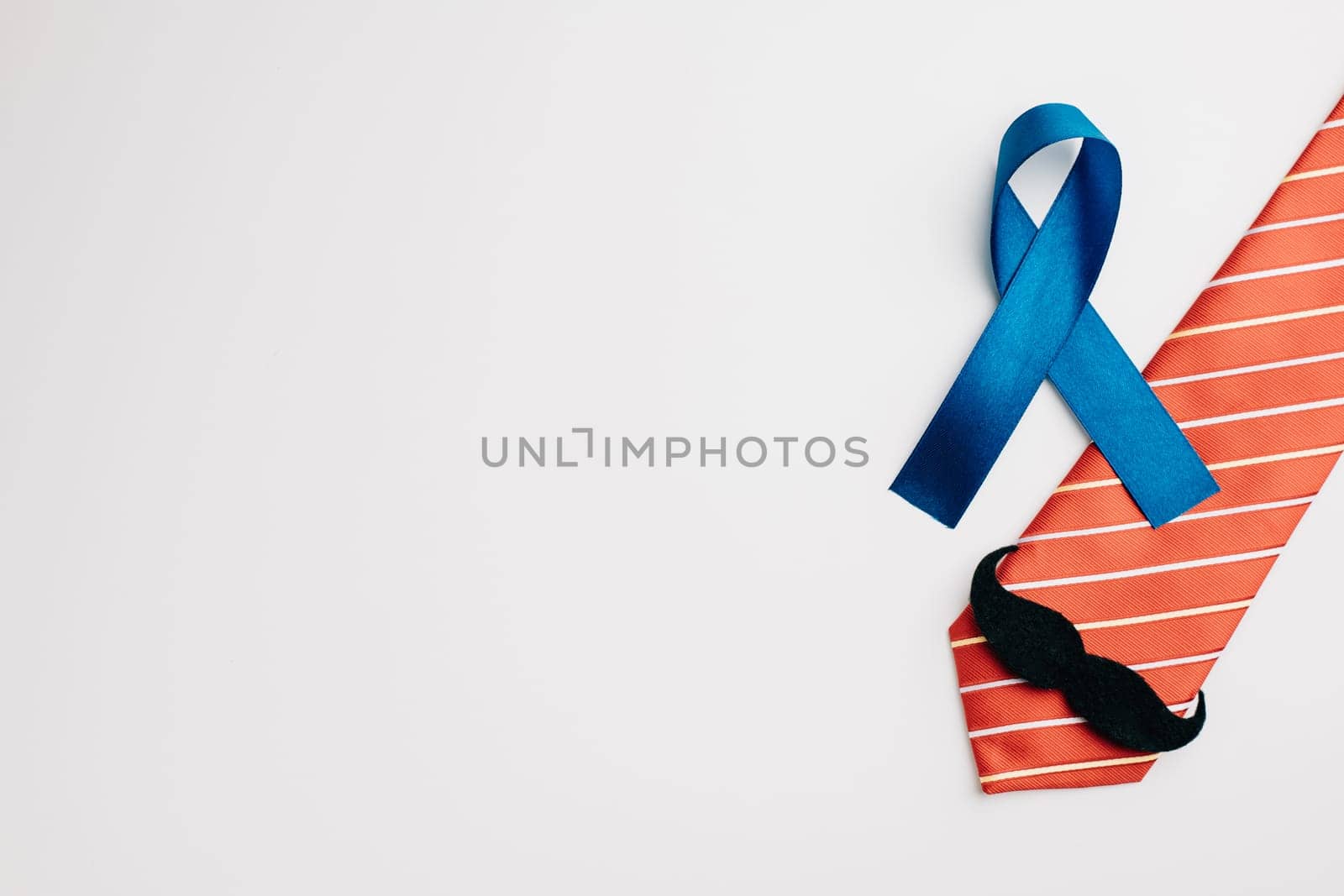 A blue ribbon, embellished with a mustache and necktie, represents Prostate Cancer Awareness and offers support to patients and their families. A symbol of men's healthcare and cancer awareness.