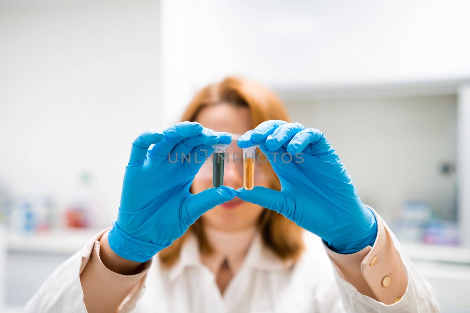 Close up two test tubes in researcher hands