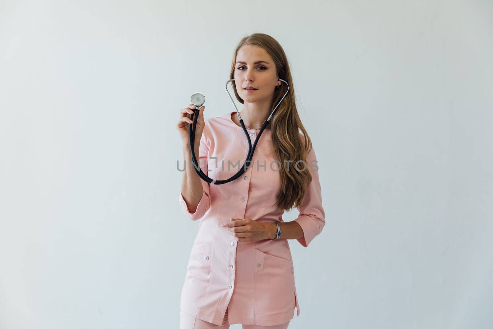 female doctor in surgical suit with phonendoscope in hospital in ward