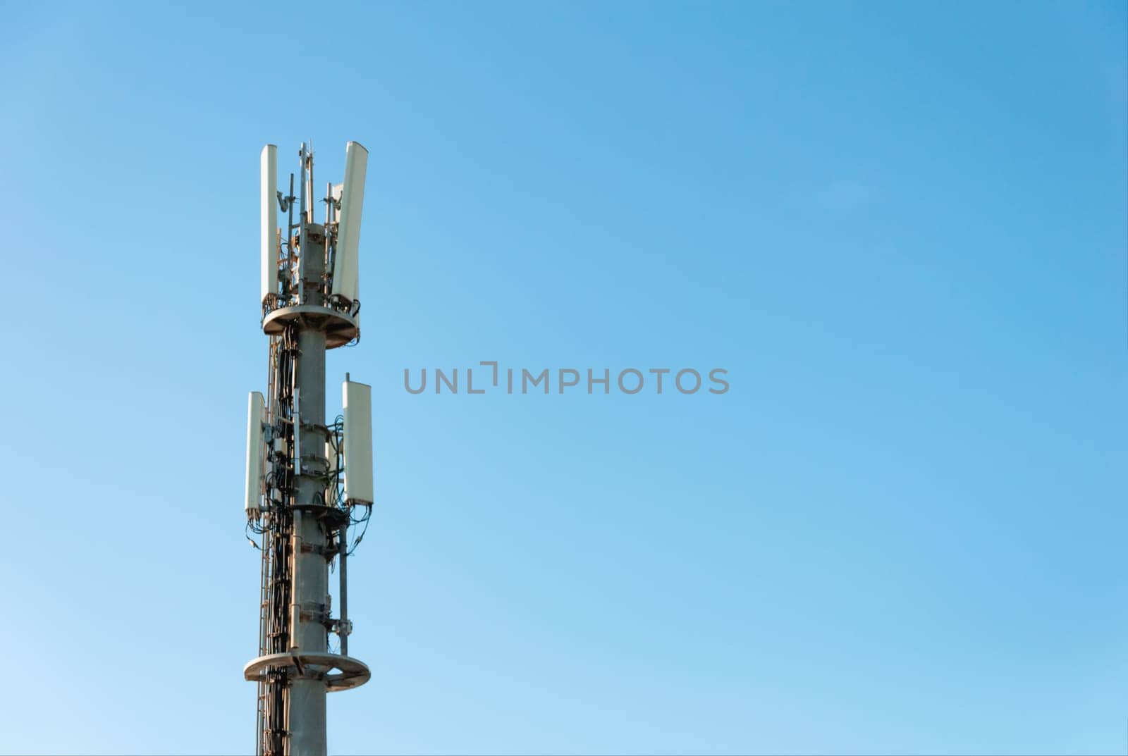 communication tower close-up over the blue sky on the right there is a place for an inscription, a shot from the height of the tower close-up. High quality photo