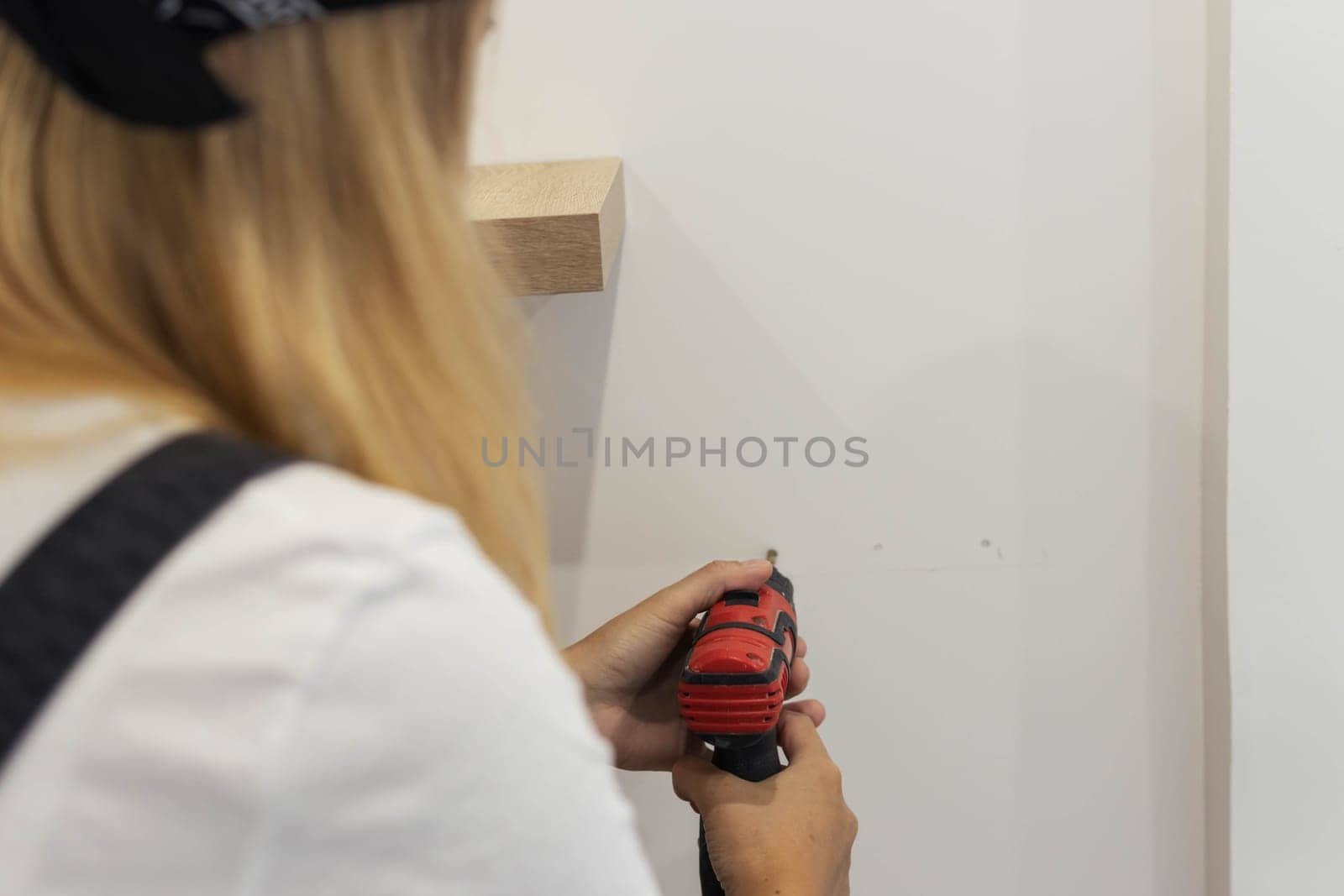 Destruction of gender stereotypes. A woman in a male work suit using various male work toolsclose-up by PopOff