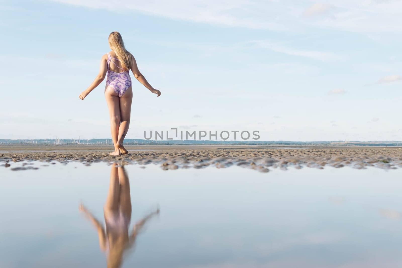 in a swimsuit image of a full length teenager girl posing from behind, enjoying the amazing ocean view, spinning and having fun, relaxing in freedom. by PopOff