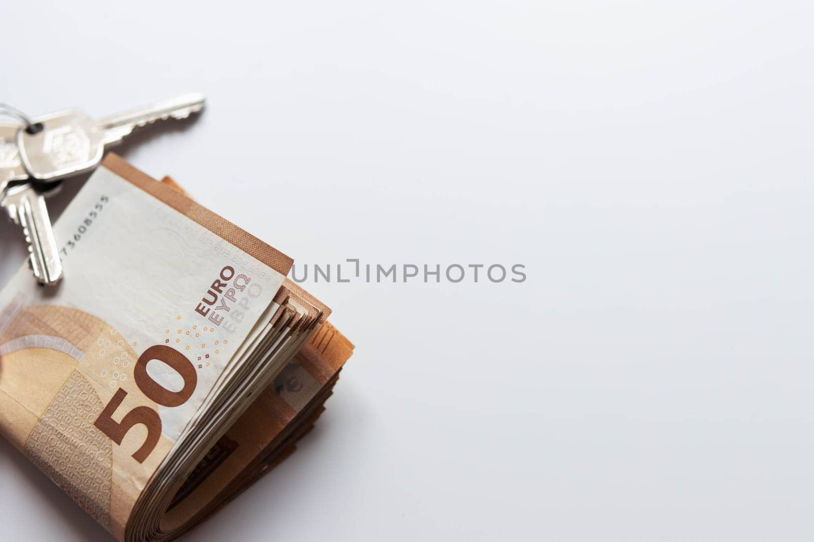 isolated on white background euro banknotes of 50 folded and next to the keys lie with the right place for the inscription. High quality photo