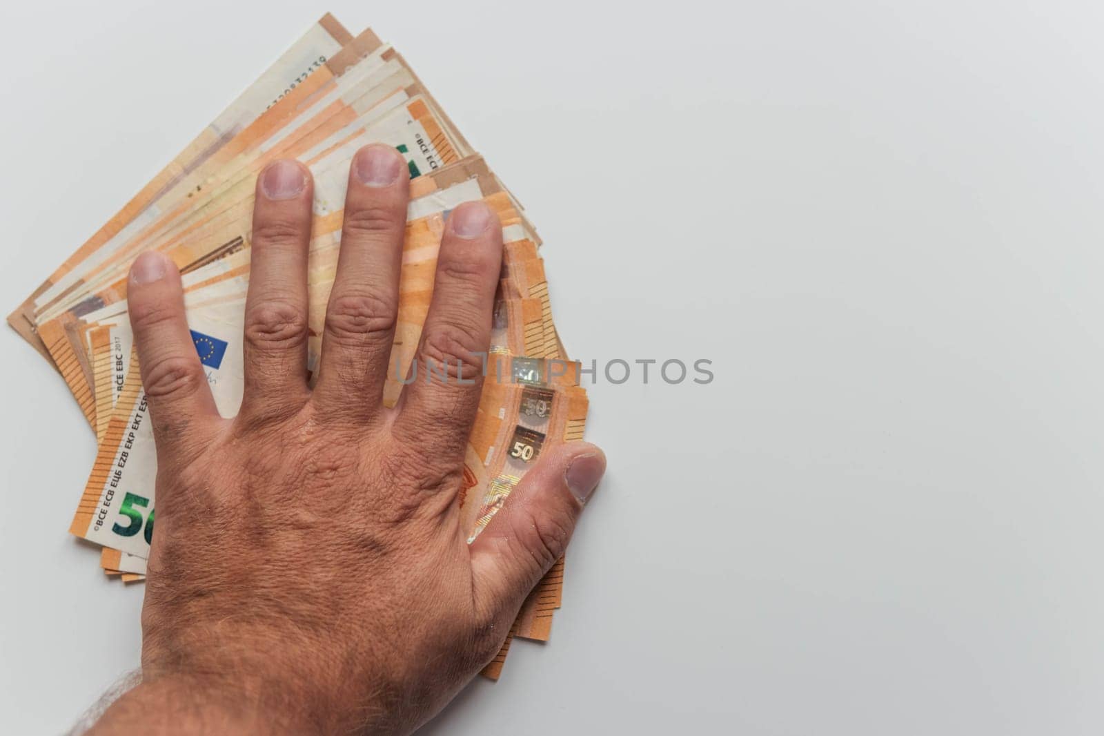 a man's hand close-up on a white background holds a hand spread out euros for 50. with the right there is a place for the inscription beautiful money background by PopOff