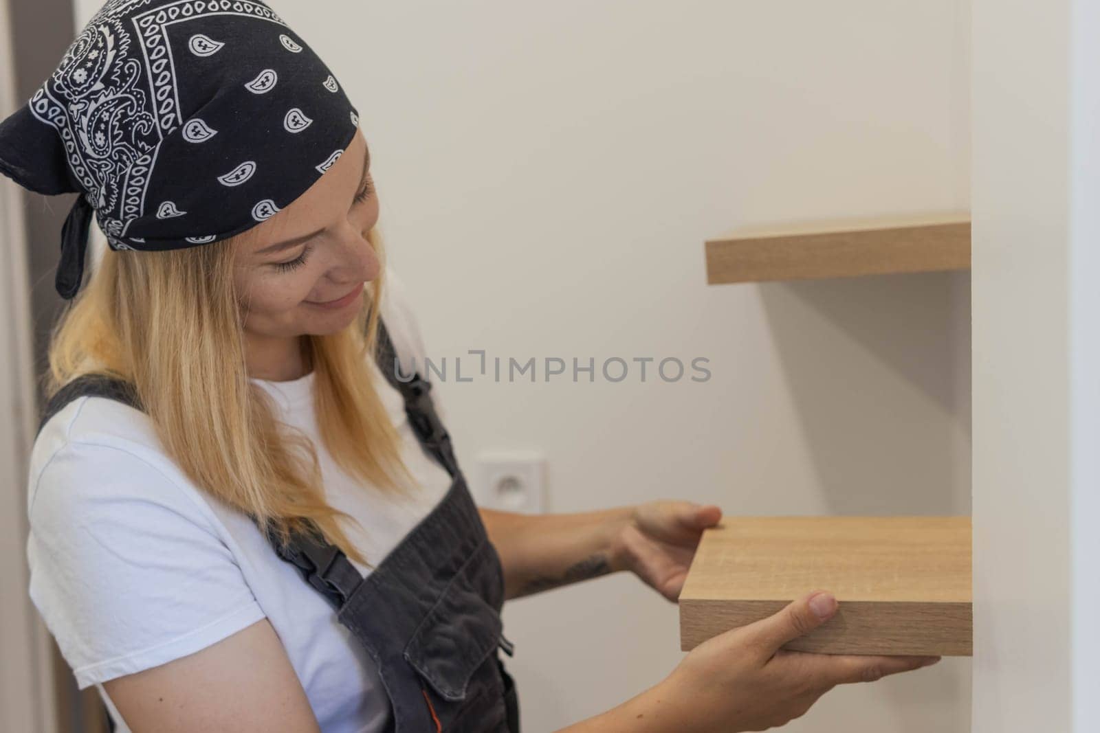 Destruction of gender stereotypes. A woman in a male work suit using various male work tools.. The girl is working on the repair of the apartment. woman in a male profession. High quality photo