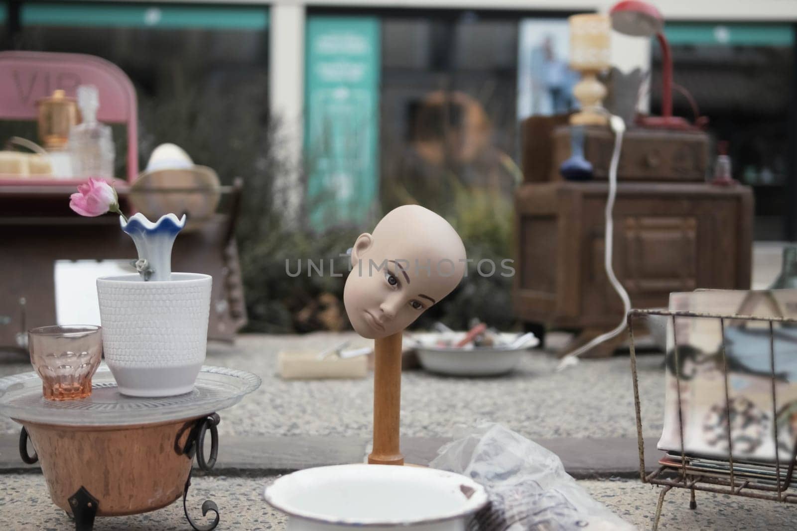 antique and old thing are sold at the fair. The head of the doll is on the rack, a lot of different by PopOff