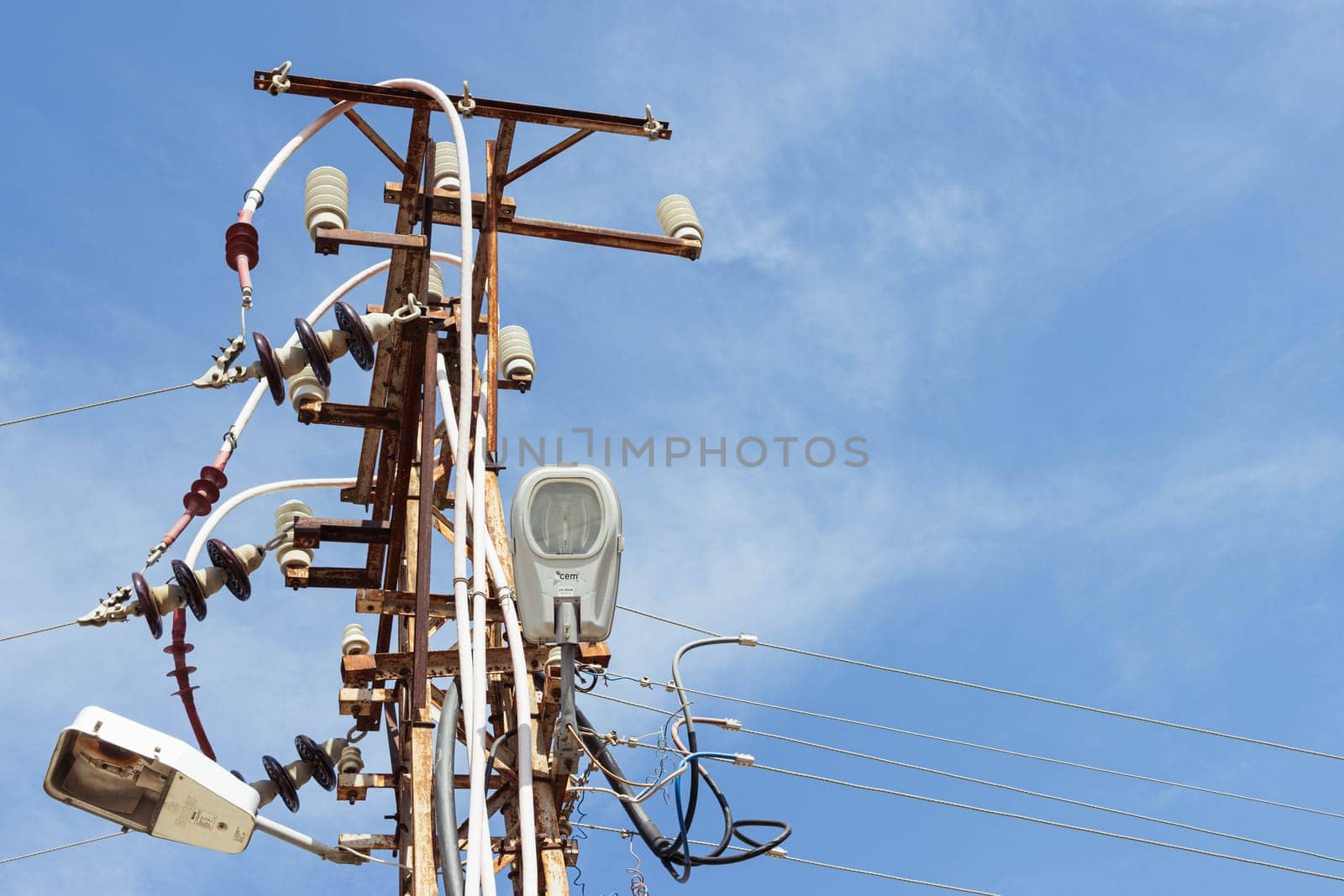 Old electric pole with many wires against the blue sky.close-up. on the right there is a place for an inscription High quality photo