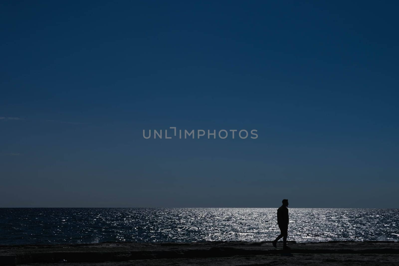 background for the phone with the sea. evening time against the background of the sea and the sky a man walks there is a place for an inscription. High quality photo