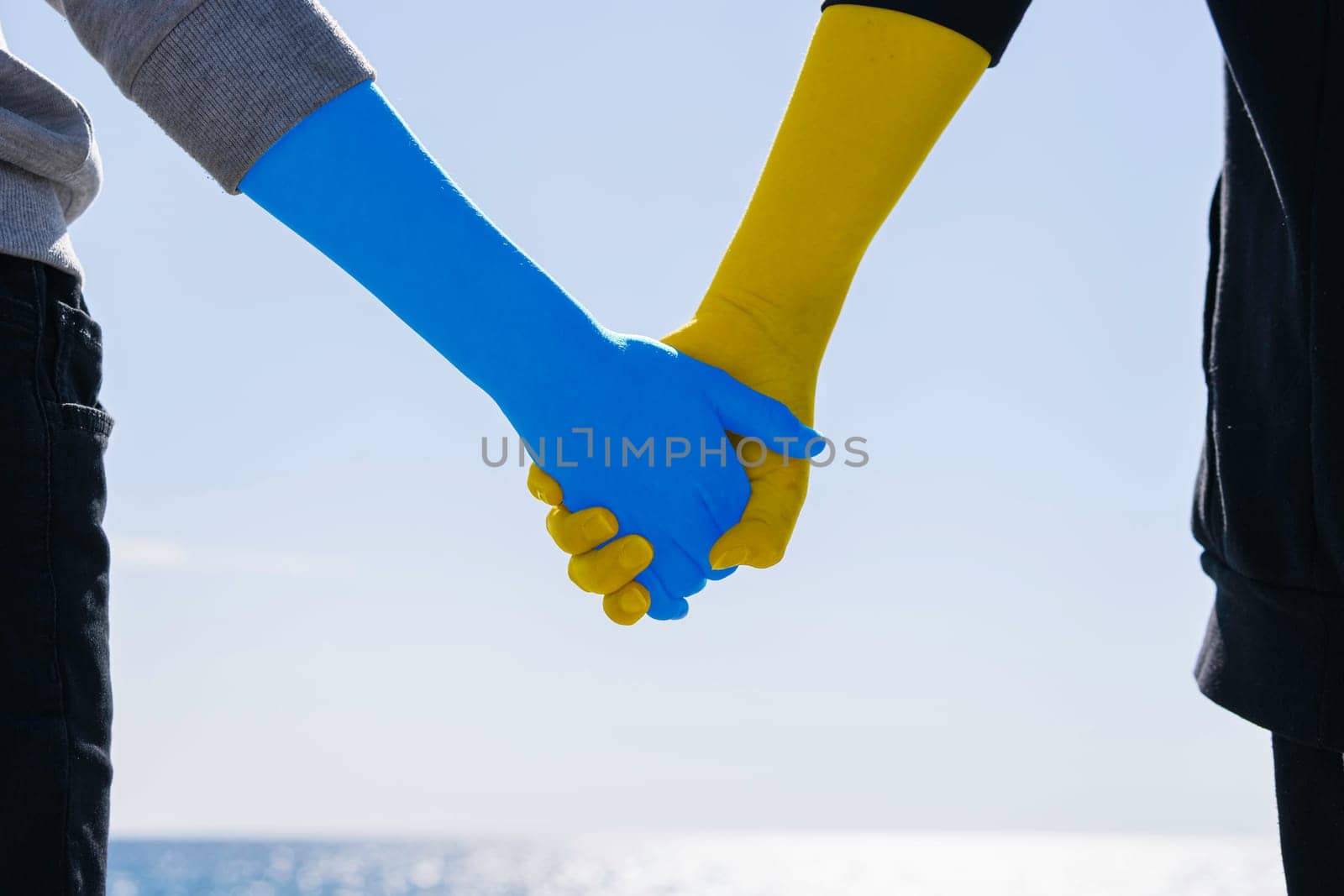 Ukraine love concept. hold hands painted in the colors of the flag by PopOff