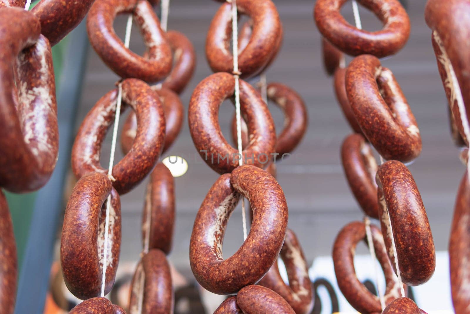 tied sausage rings hang on a rope.in a street market. High quality photo