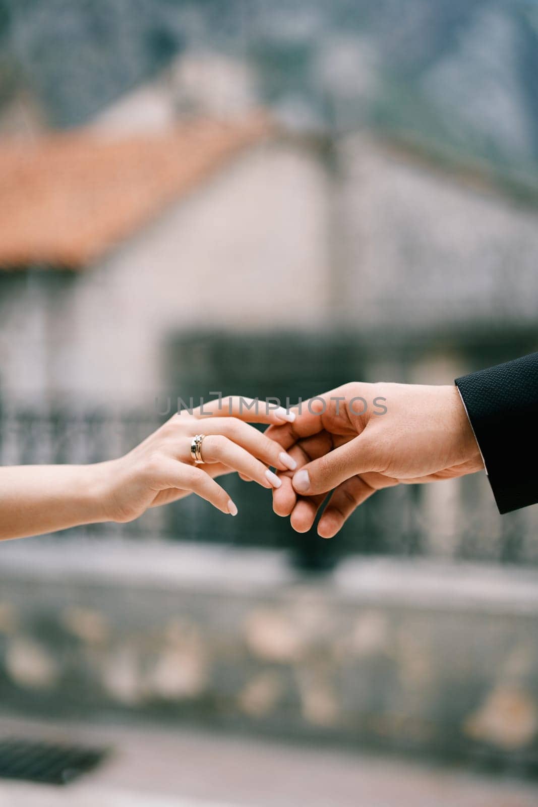 Bride hand touches groom hand. Cropped. Faceless by Nadtochiy