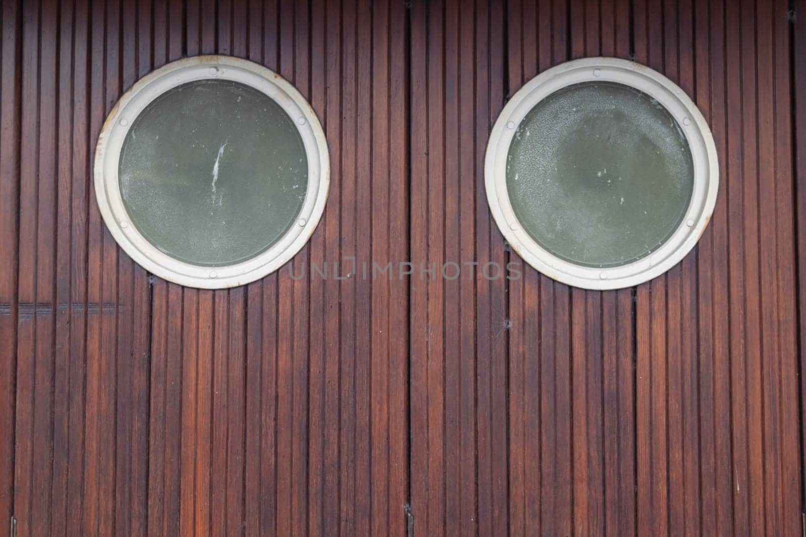 small round two windows in brown doors, brown background texture with a place for an inscription. by PopOff