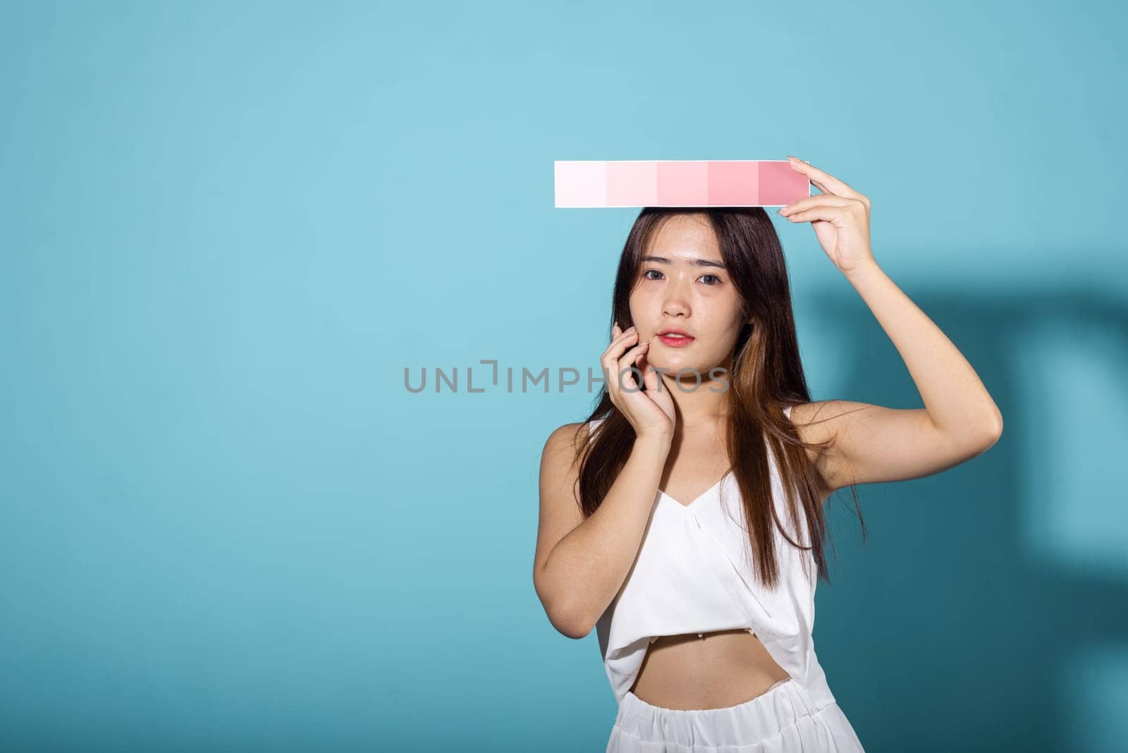 Asian beautiful young woman holding skin color scale paper by Sorapop