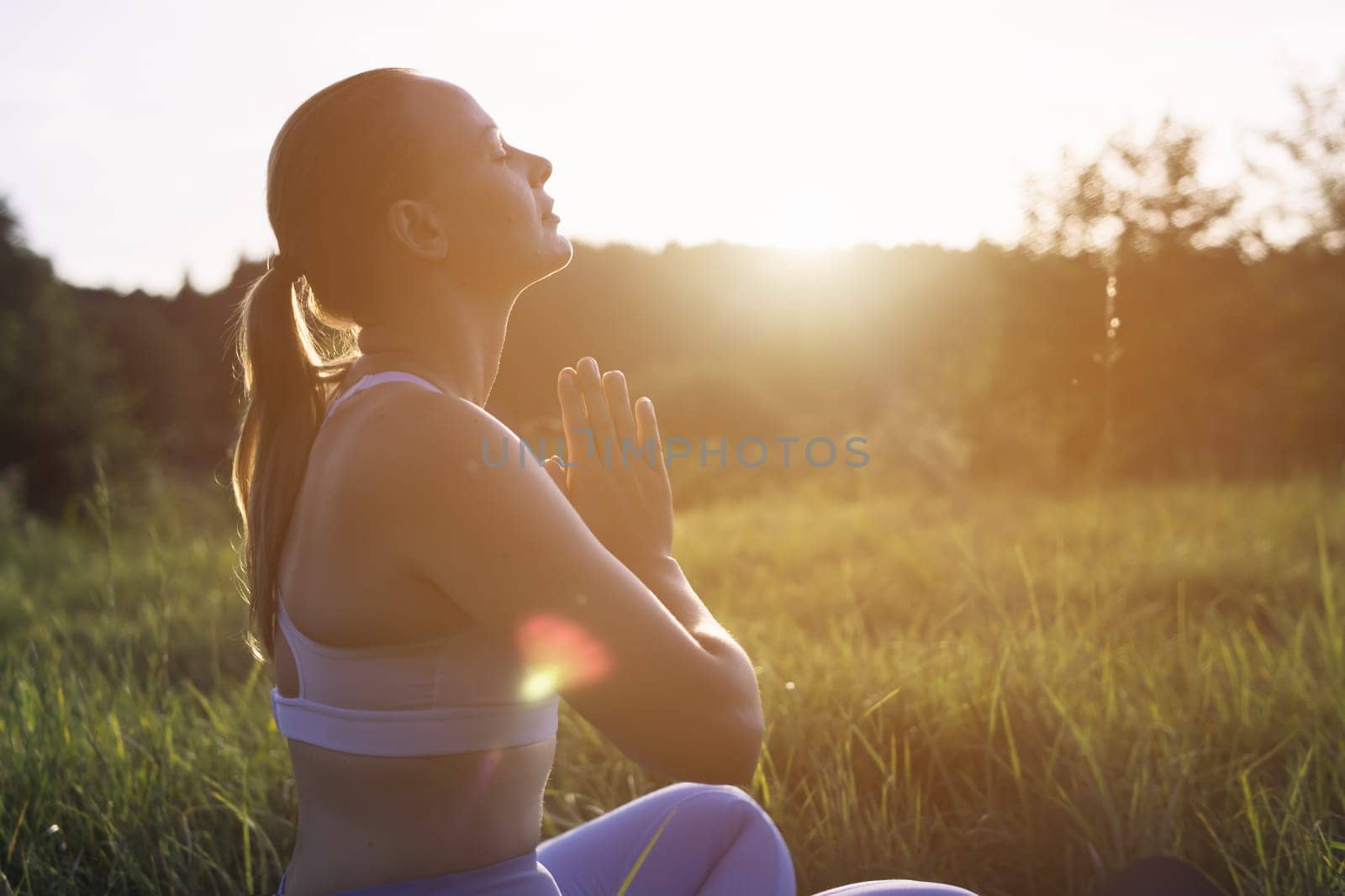 silhouette of a girl of European appearance at sunset, there is a place for an inscription on the side, the girl is doing yoga young girl doing yoga outdoors. High quality photo